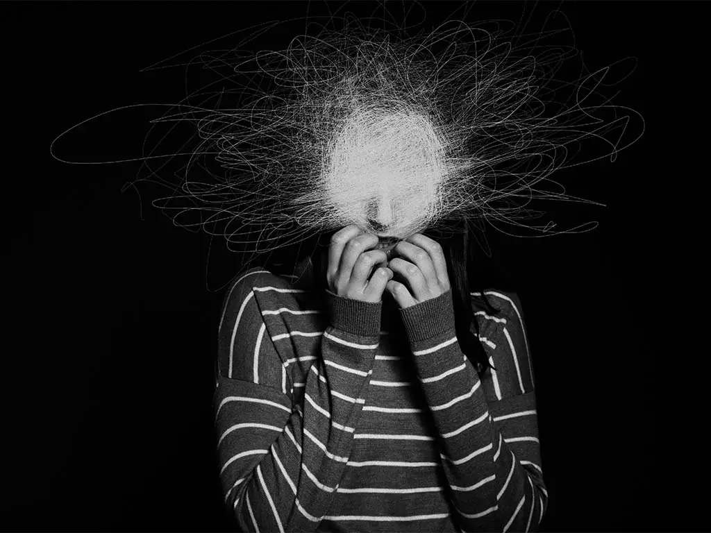 Person overwhelmed by mental noise representing difficulty hearing internal signals and body communication